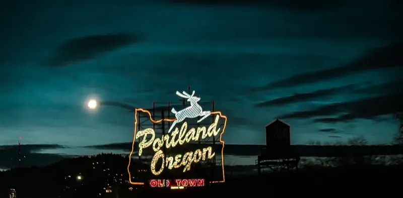 a neon sign that reads portland oregon at night