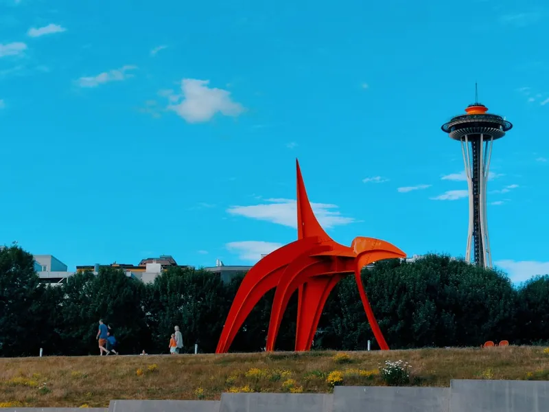 a red sculpture in front of a tower