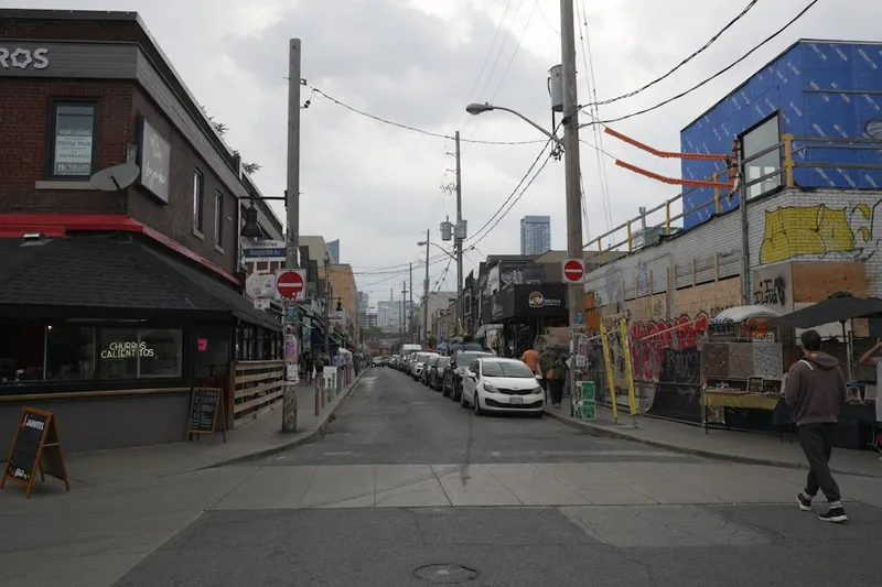 a man walking down a street next to tall buildings