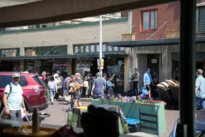 A crowd of people walking down a street next to tall buildings
