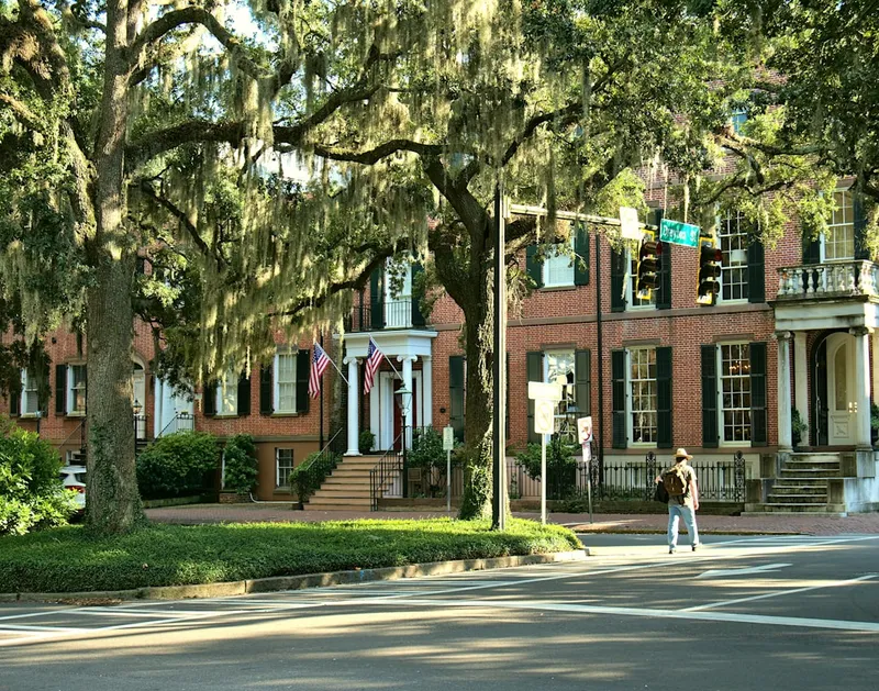 A man walking across a street in front of a building