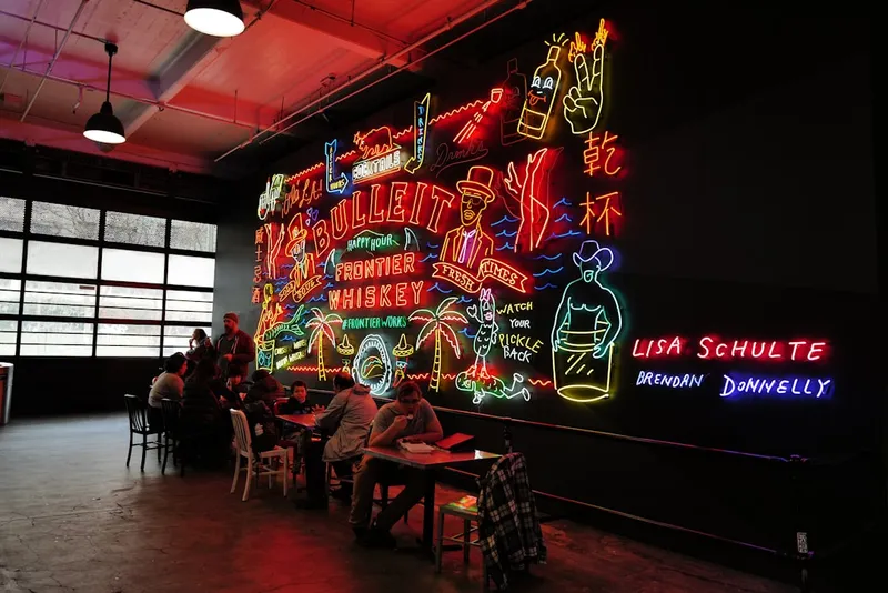 Colorful neon sign art installation with people